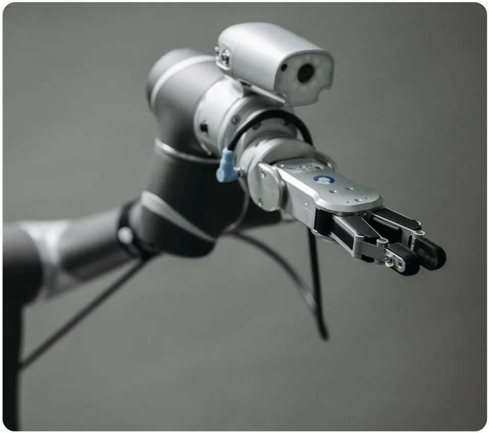 Close-up of a robotic arm end effector with an integrated camera and precision gripper